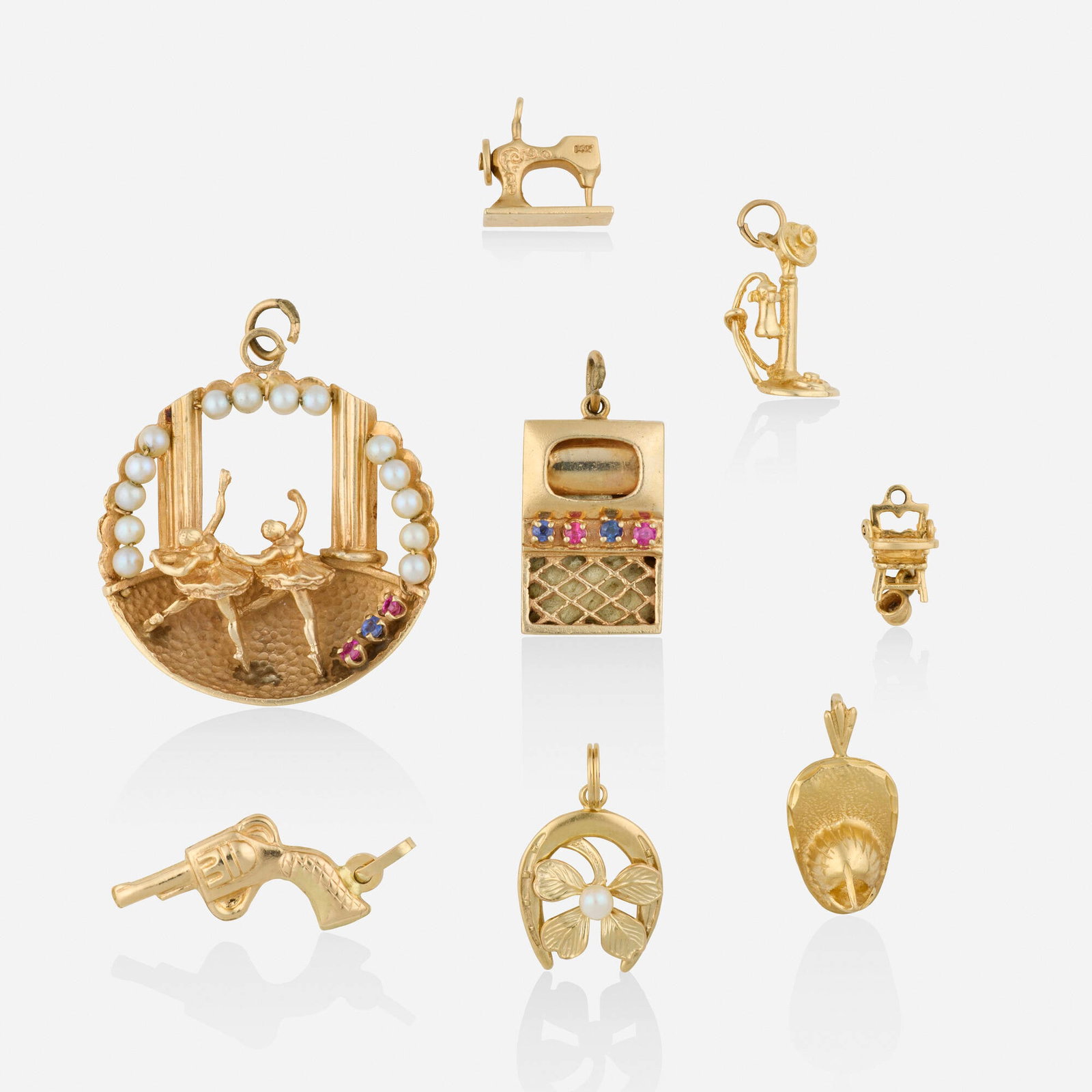 Group of gold charms: Group of gold charms Comprising eight charms, including a ballerina set with cultured pearls, circular-cut rubies and sapphire; a TV set with circular-cut rubies and sapphires; a horseshoe and four-le