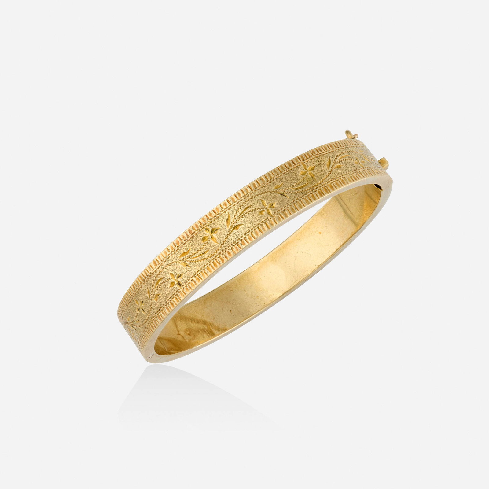 Gold bracelet: Gold bracelet The hinged bangle of engraved design 18k yellow gold Inner circ. 6.75 in, width 0.375 in; Gross weight 17.1 dwts This work will ship from Lambertville, New Jersey.