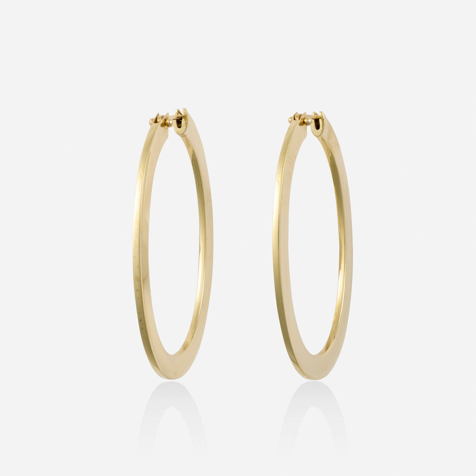 Gold earrings: Gold earrings Each an oval hoop Yellow gold Approx. 1.75 x 0.125 in; Gross weight 4.1 dwts This work will ship from Lambertville, New Jersey.