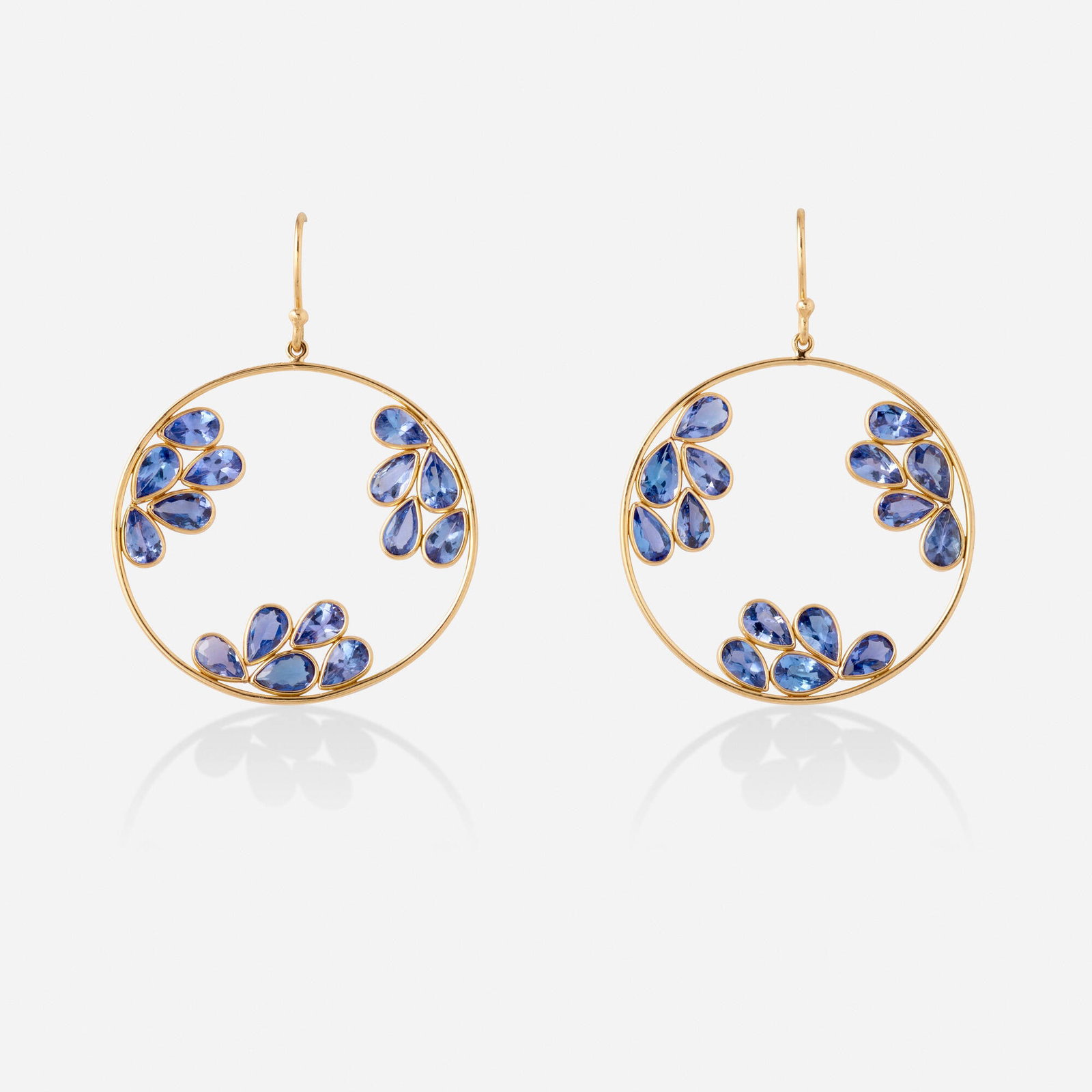 Tanzanite and gold earrings: Tanzanite and gold earrings Of circular outline, set with pear-shaped tanzanite 18k yellow gold 1.50 x 1.25 in; Gross weight 2.7 dwts This work will ship from Lambertville, New Jersey.