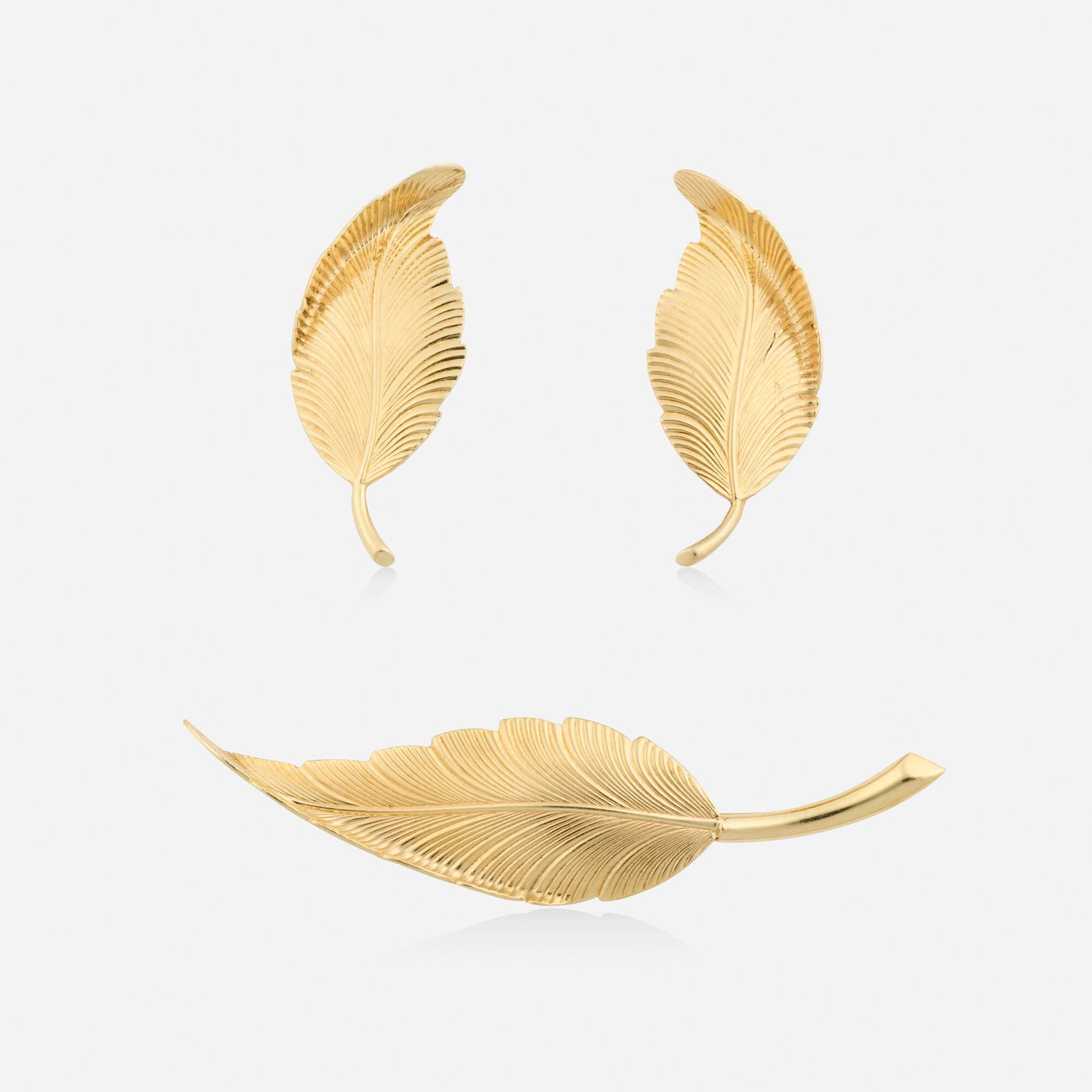 Tiffany & Co., Gold earrings and brooch: Tiffany & Co. Gold earrings and brooch Each a textured gold leaf 14k yellow gold Signed Tiffany & Co. to each example Brooch 2.375 x 0.625 in, earrings 1.25 x 0.50 in; Gross weight 6.3 dwts Sol