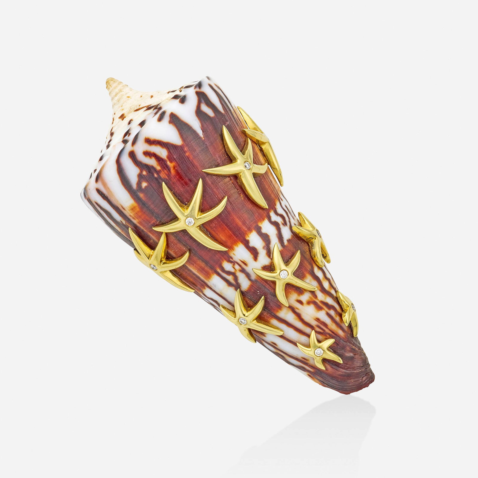 Shell, diamond, and gold brooch: Shell, diamond, and gold brooch The shell, enhanced by gold starfish set with round brilliant-cut diamonds 18k yellow gold 2.75 x 1.25 in; Gross weight 32.3 dwts This work will ship from Lambertville,