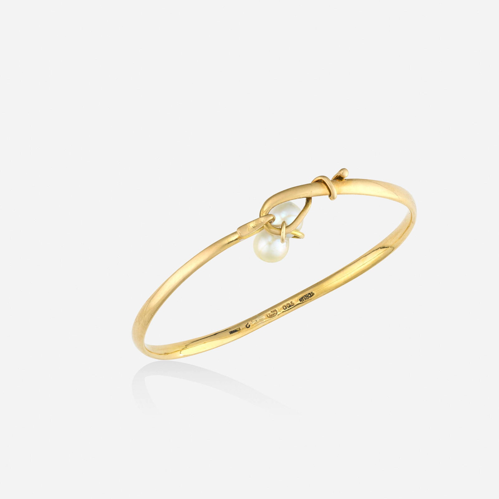 Vivianna Torun Bulow-Hube for Georg Jensen, Cultured pearl and gold bracelet: Vivianna Torun Bulow-Hube for Georg Jensen Cultured pearl and gold bracelet The bangle bracelet with a hanging cultured pearl pendant; after 1945 18k yellow gold Signed with maker's marks for Viv