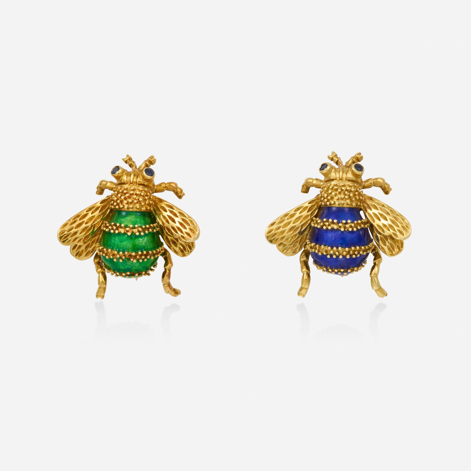 Two sapphire, enamel, and gold brooches: Two sapphire, enamel, and gold brooches Each bee set with circular-cut sapphire eyes and blue or green enamel body 18k yellow gold 0.875 x 0.875 in; Gross weight 9.6 dwts This work will ship from Lamb