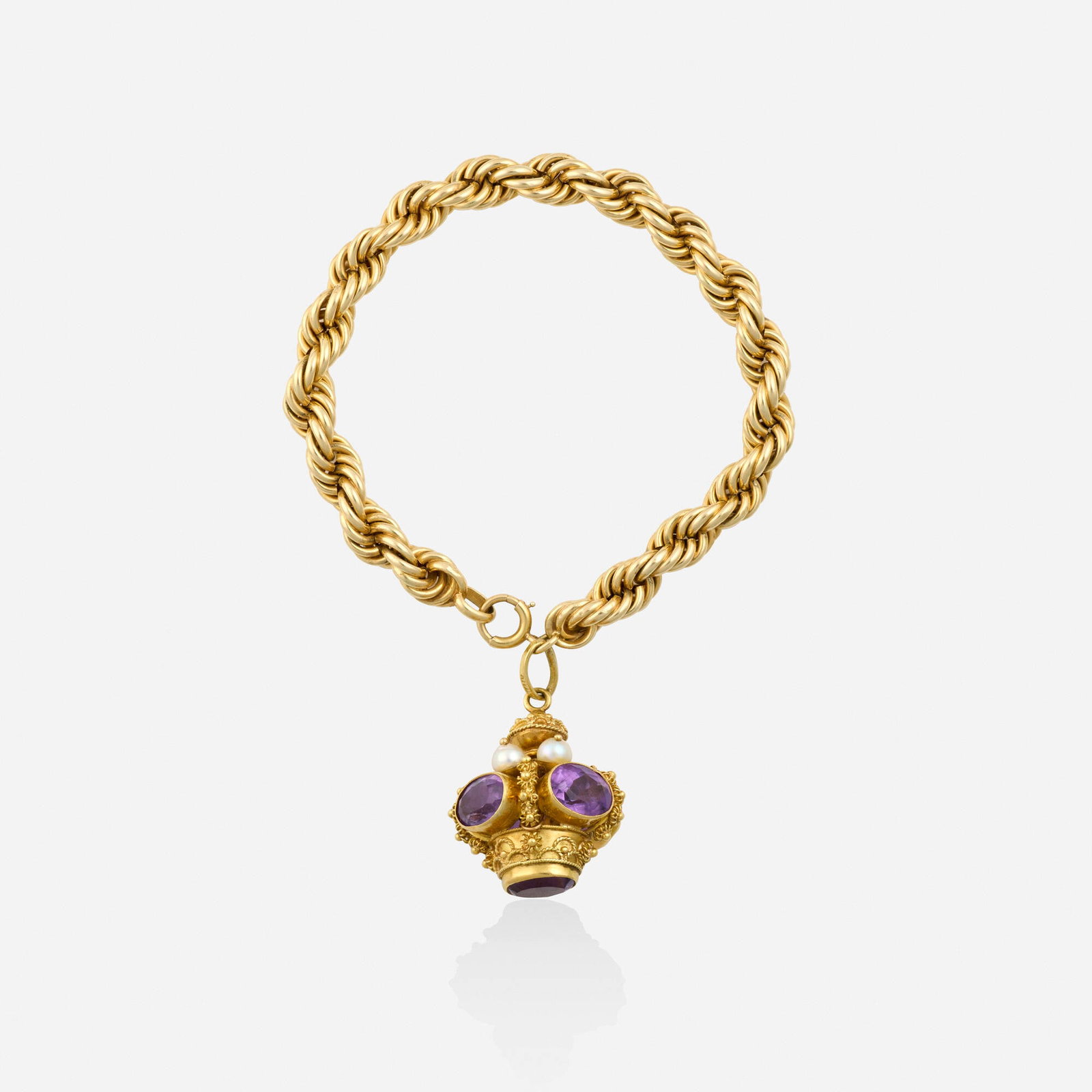 Amethyst, cultured pearl, and gold bracelet: Amethyst, cultured pearl, and gold bracelet Comprising a roped gold bracelet, suspending a crown charm of gold granulation and wirework, set with oval-cut amethyst and cultured pearls Yellow gold 8 in