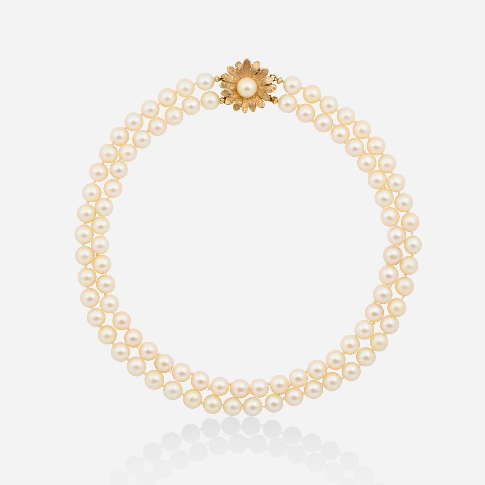 Cultured pearl and gold necklace: Cultured pearl and gold necklace Designed with two strands of cultured pearls, joined by a floral clasp set with a cultured pearl 14k yellow gold 15 in; Gross weight 34.1 dwts This work will ship from