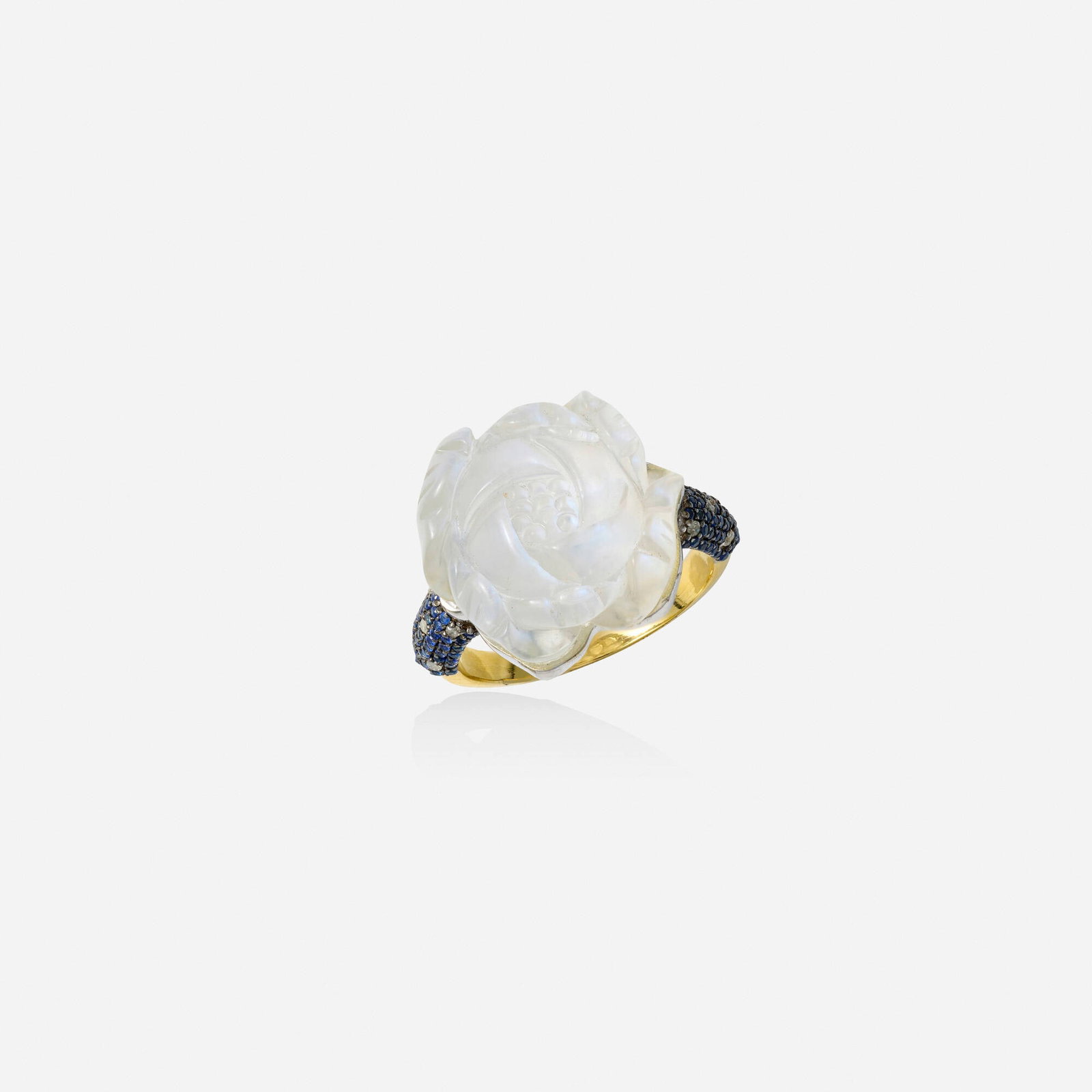 Moonstone, sapphire, and diamond ring: Moonstone, sapphire, and diamond ring Set with a carved moonstone flower, the shoulders pave-set with circular-cut sapphires and single-cut diamonds Silver, yellow gold Ring size 6.25; Gross weight 4.