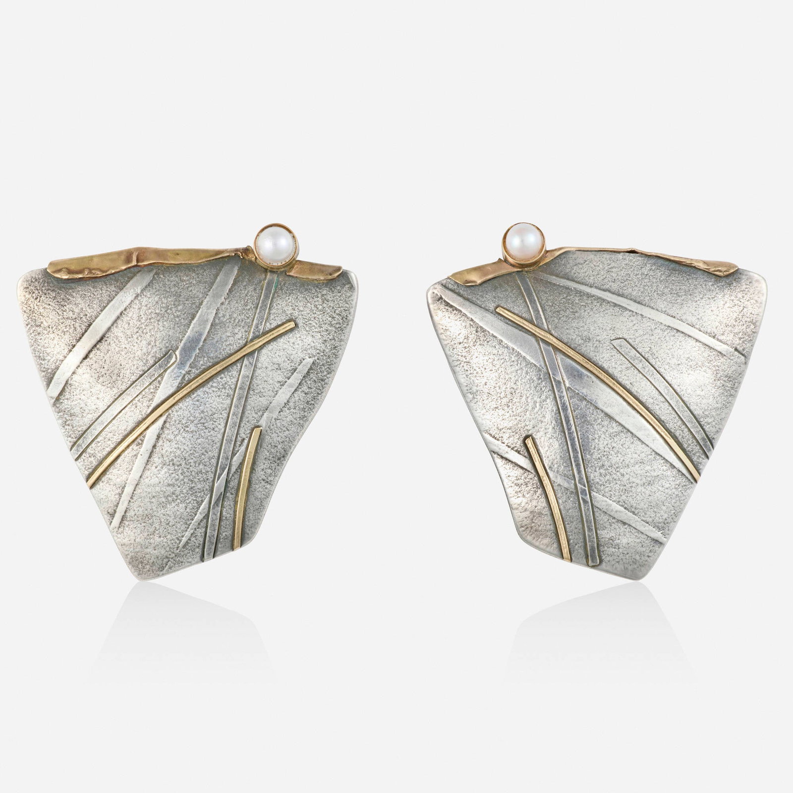 Carolyn Morris Bach, Cultured pearl, silver, and gold earrings: Carolyn Morris Bach Cultured pearl, silver, and gold earrings Each of textured design, set with a cultured pearl Silver, yellow gold Signed Carolyn Morris Bach 1.50 x 1.375 in; Gross weight 10.7