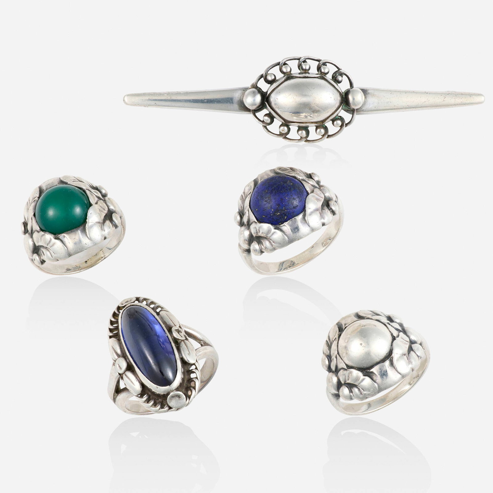Georg Jensen, Group of multi-gem and silver jewelry: Georg Jensen Group of multi-gem and silver jewelry Comprising a bar brooch, no. 195, 1910-1925; a ring set with cabochon green chalcedony, no. 11, 1915-1297; a ring set with cabochon lapis lazuli, no.