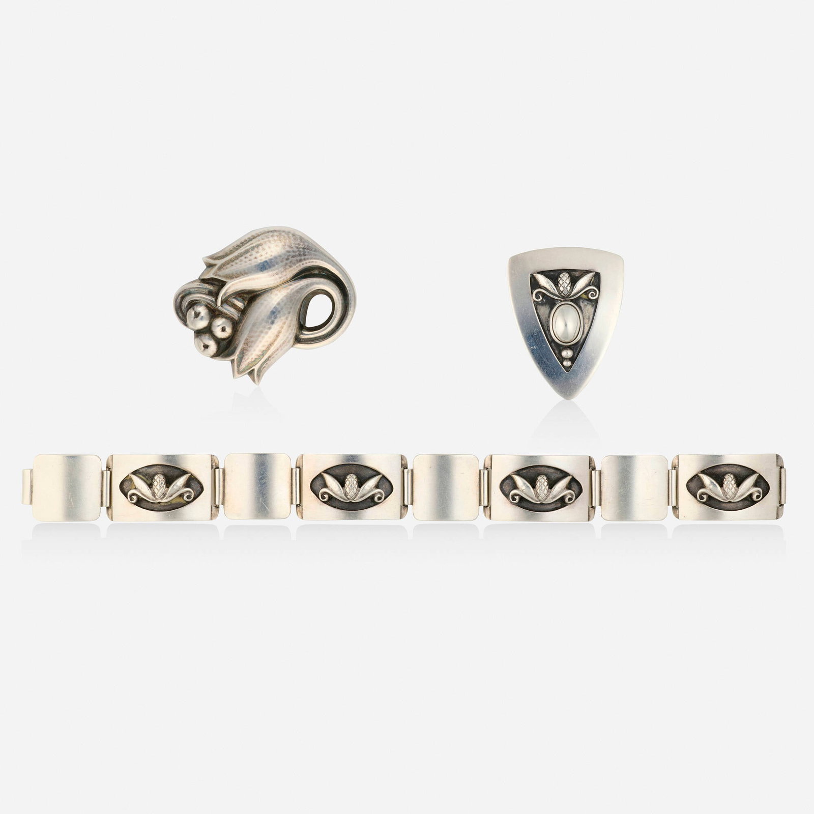 Georg Jensen and Georg Jensen Inc. USA, Group of sterling silver jewelry: Georg Jensen and Georg Jensen Inc. USA Group of sterling silver jewelry Comprising a tulip and berry brooch, no. 100C; a pinecone brooch and bracelet, designed by Laurence Foss, no. 480A and 429B; aft