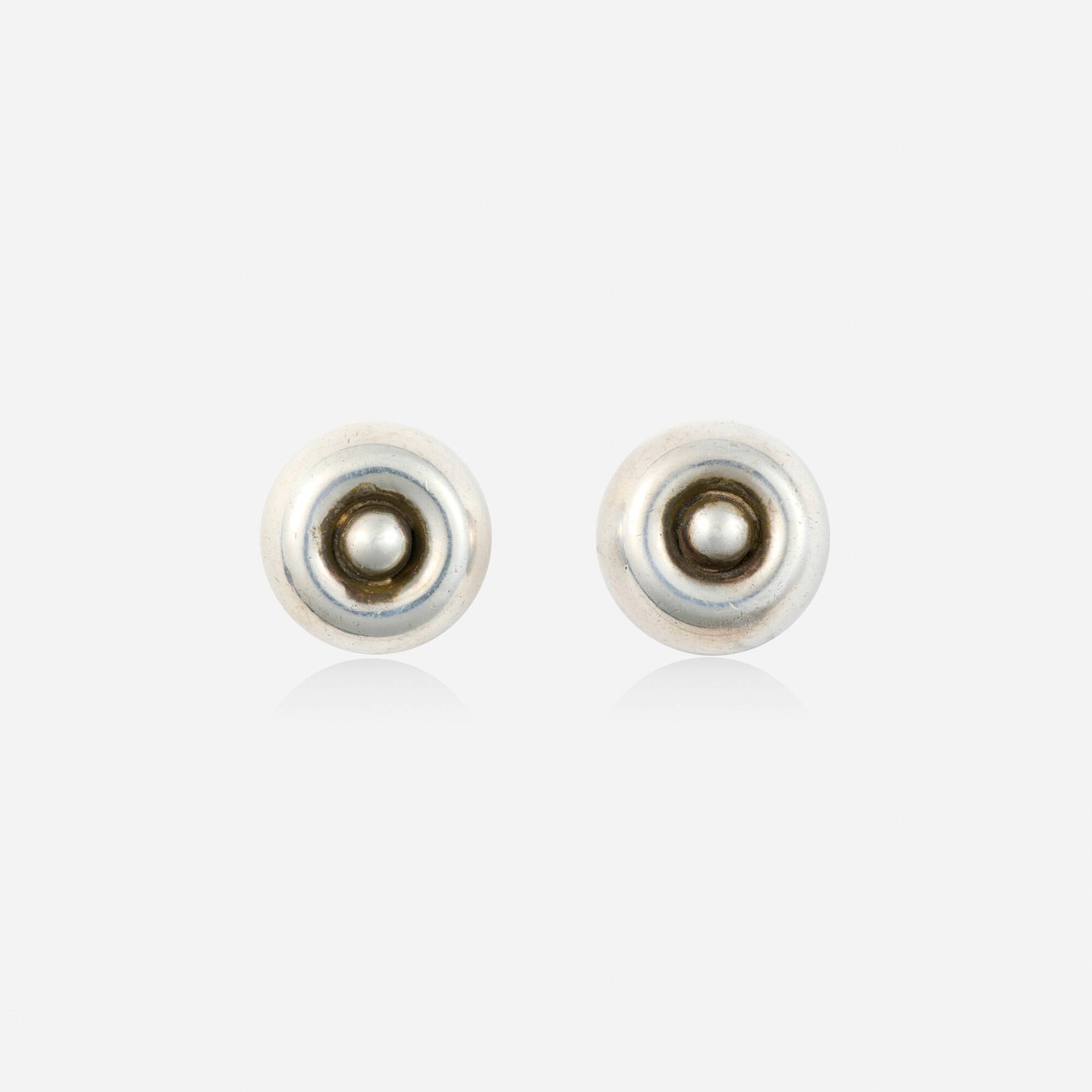 Hector Aguilar, Silver earrings: Hector Aguilar Silver earrings Of circular design Silver Signed with maker's mark for Hector Aguilar 0.625 in; Gross weight 5.2 dwts This work will ship from Lambertville,