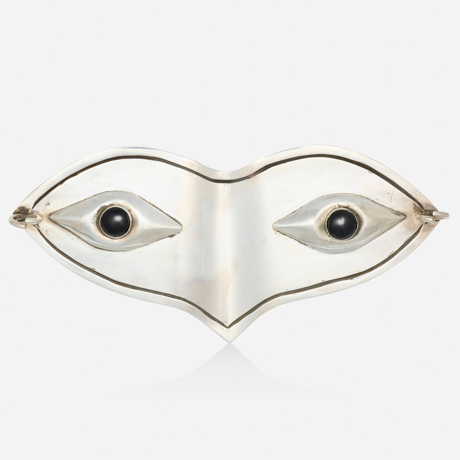 Hubert Harmon, Black onyx and sterling silver belt buckle: Hubert Harmon Black onyx and sterling silver belt buckle Designed as a masquerade mask set with cabochon black onyx eyes; 1944-1948 Sterling silver Signed Hubert Harmon 5.50 x 2.50 in; Gross weigh