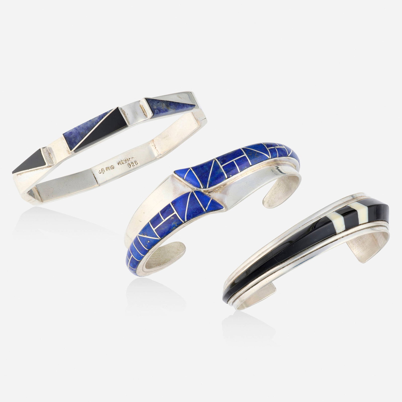 Three multi-gem and sterling silver bracelets: Three multi-gem and sterling silver bracelets Comprising one cuff bracelet inlaid with black onyx and white agate by Jack Woolsey; a cuff bracelet inlaid with lapis lazuli; and a hinged bangle bracele