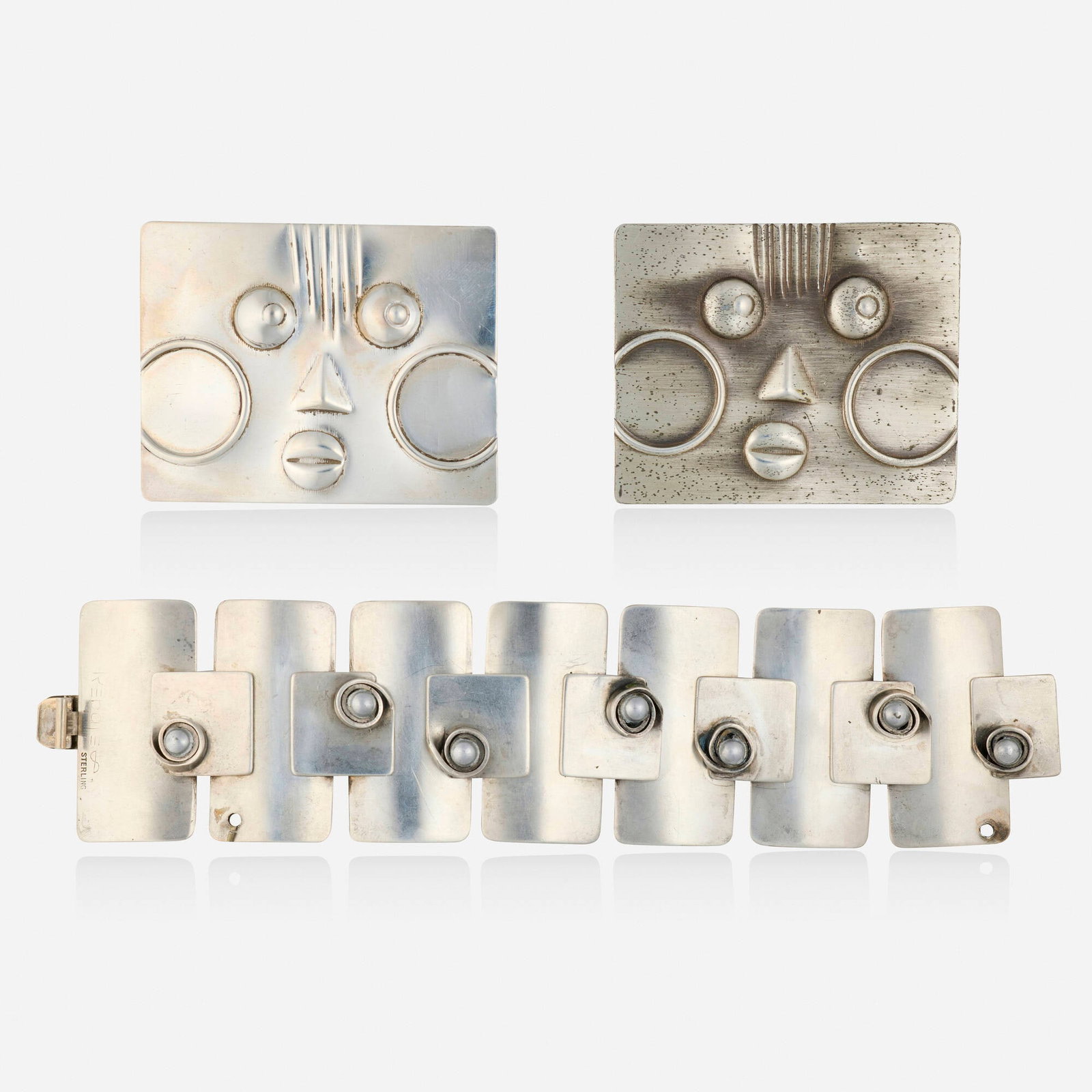 Francisco Rebajes, Group of sterling silver jewelry: Francisco Rebajes Group of sterling silver jewelry Comprising two mask brooches and a rectangular link bracelet Sterling silver Signed Rebajes to each example Brooches approx. 2.375 x 1.875 in, br