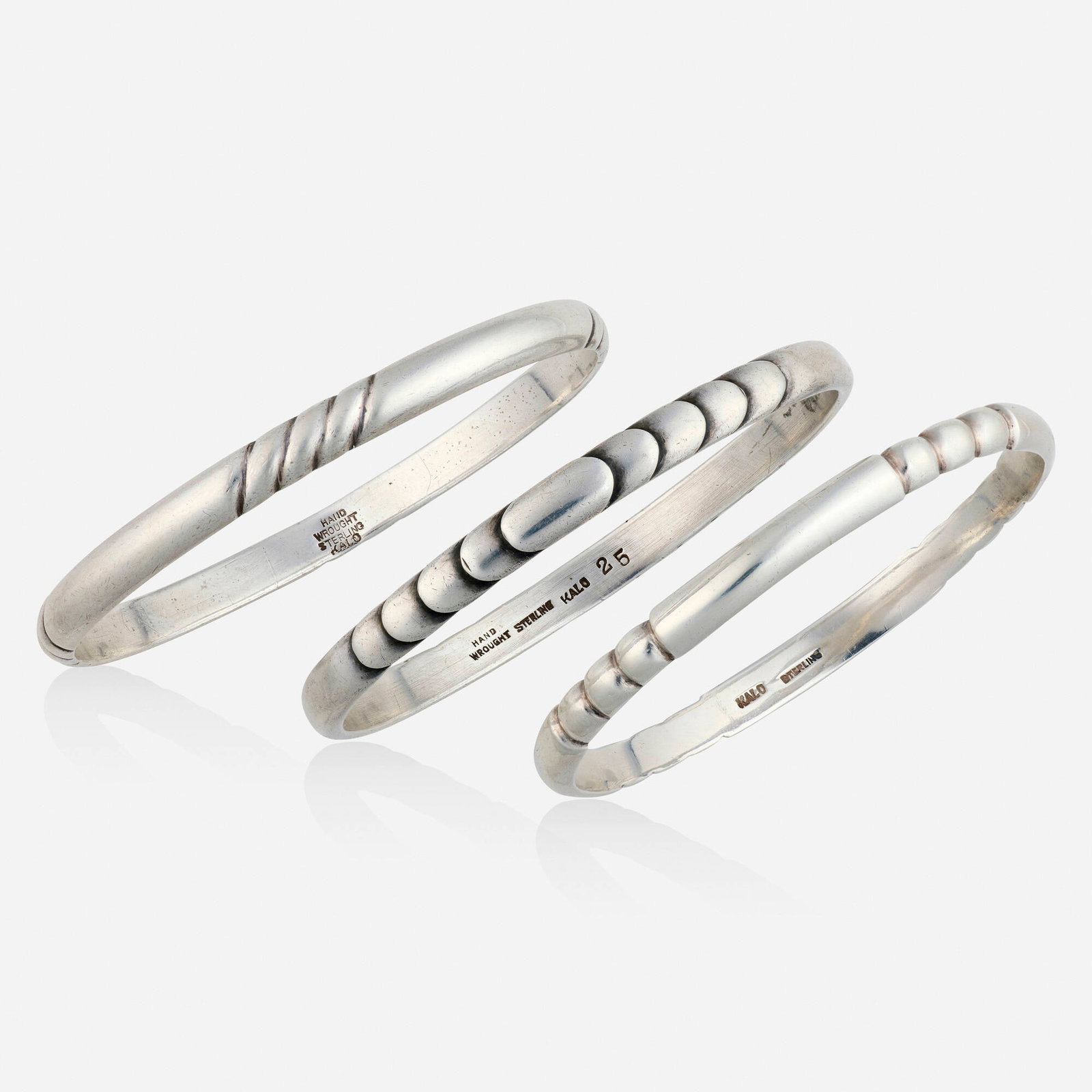 The Kalo Shop, Three sterling silver bracelets: The Kalo Shop Three sterling silver bracelets Each bangle of textured design Sterling silver Signed Kalo to each example Inner circs. 7.75 in, 7.50 in, 7.125 in, width 0.25 in; Gross weight 55.0 d