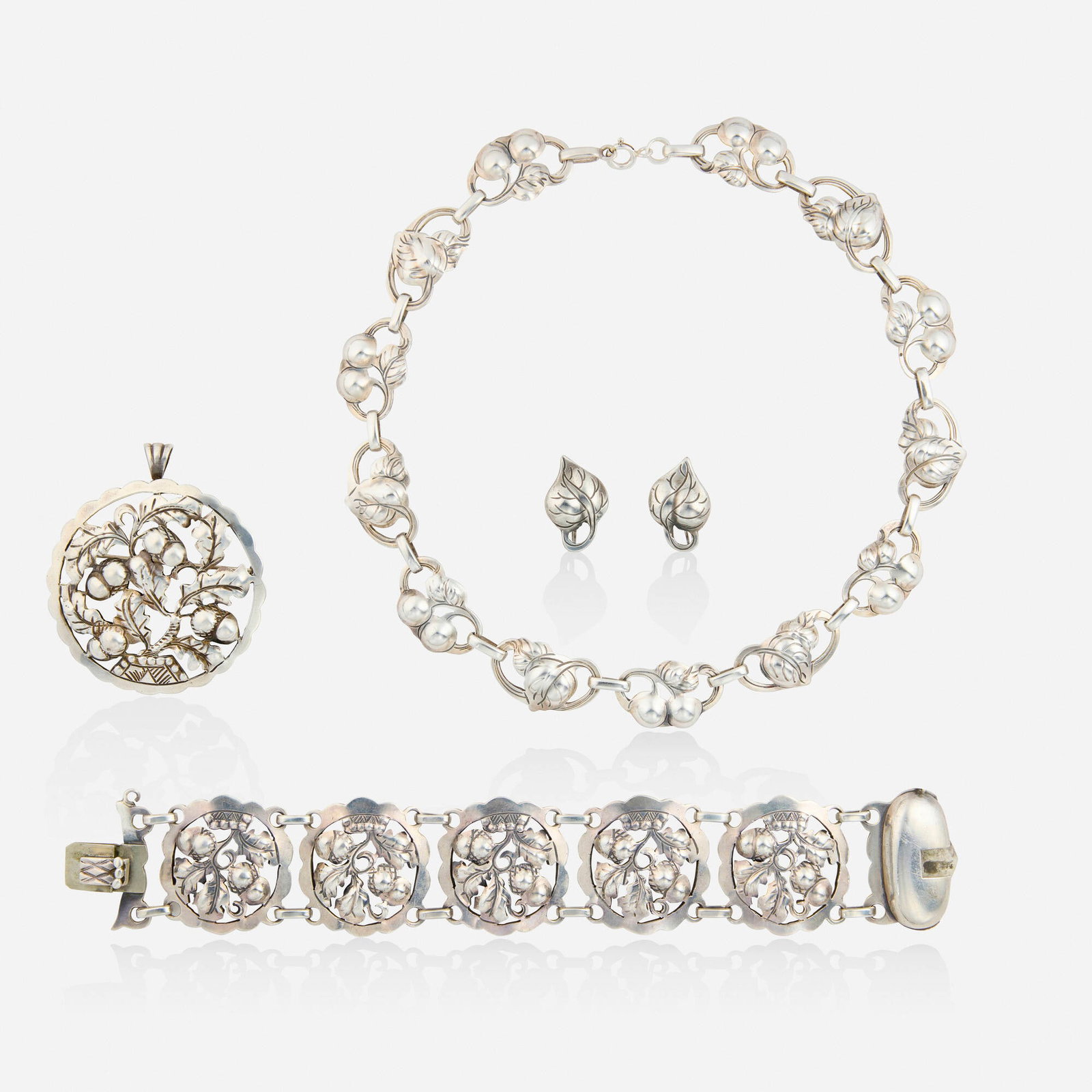 The Kalo Shop, Group of sterling silver jewelry: The Kalo Shop Group of sterling silver jewelry Comprising a necklace of cherry motif, a pair of leaf earrings, and a bracelet and pendant brooch of acorn and oak leaf motifs Sterling silver Signed Kal