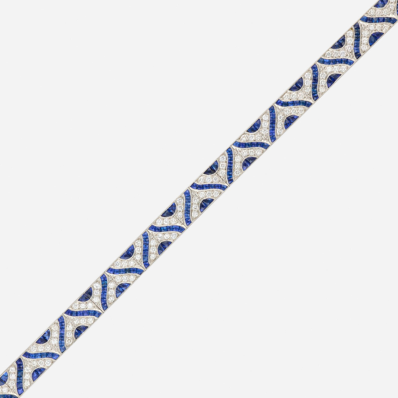 Diamond, synthetic sapphire, and platinum bracelet: Diamond, synthetic sapphire, and platinum bracelet Set with calibre-cut synthetic sapphires and round brilliant-cut diamonds Platinum 6.25 x 0.25 in; Gross weight 20.4 dwts Sold with extra link