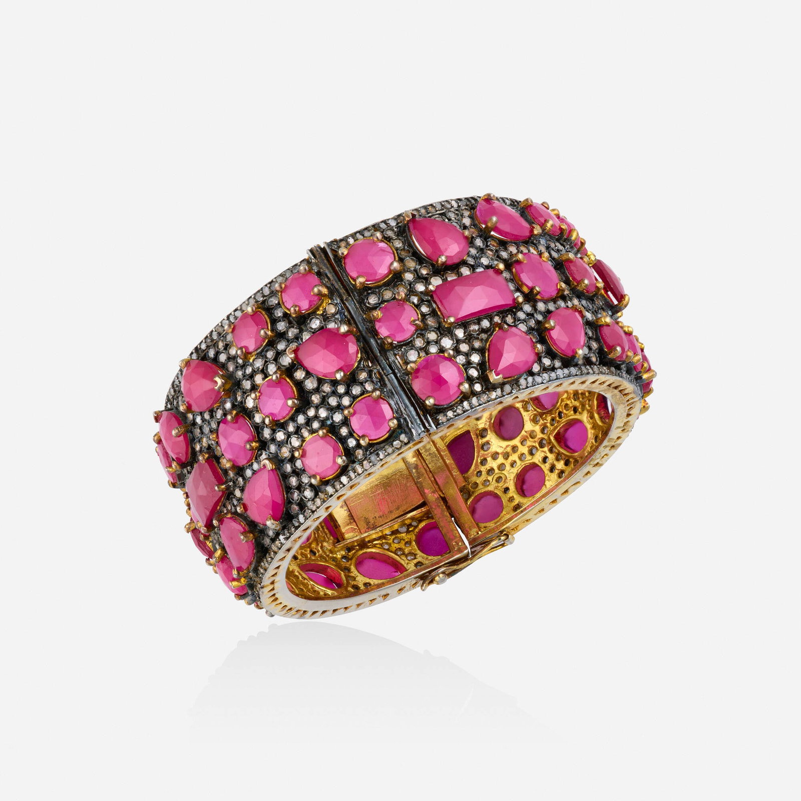 Ruby, diamond, and silver gilt bracelet: Ruby, diamond, and silver gilt bracelet The hinged bangle bracelet, set with rose-cut diamonds, pear, rectangular, and circular-cut rubies Silver gilt Inner circ. 7 in, width 1.25 in; Gross weight 72.