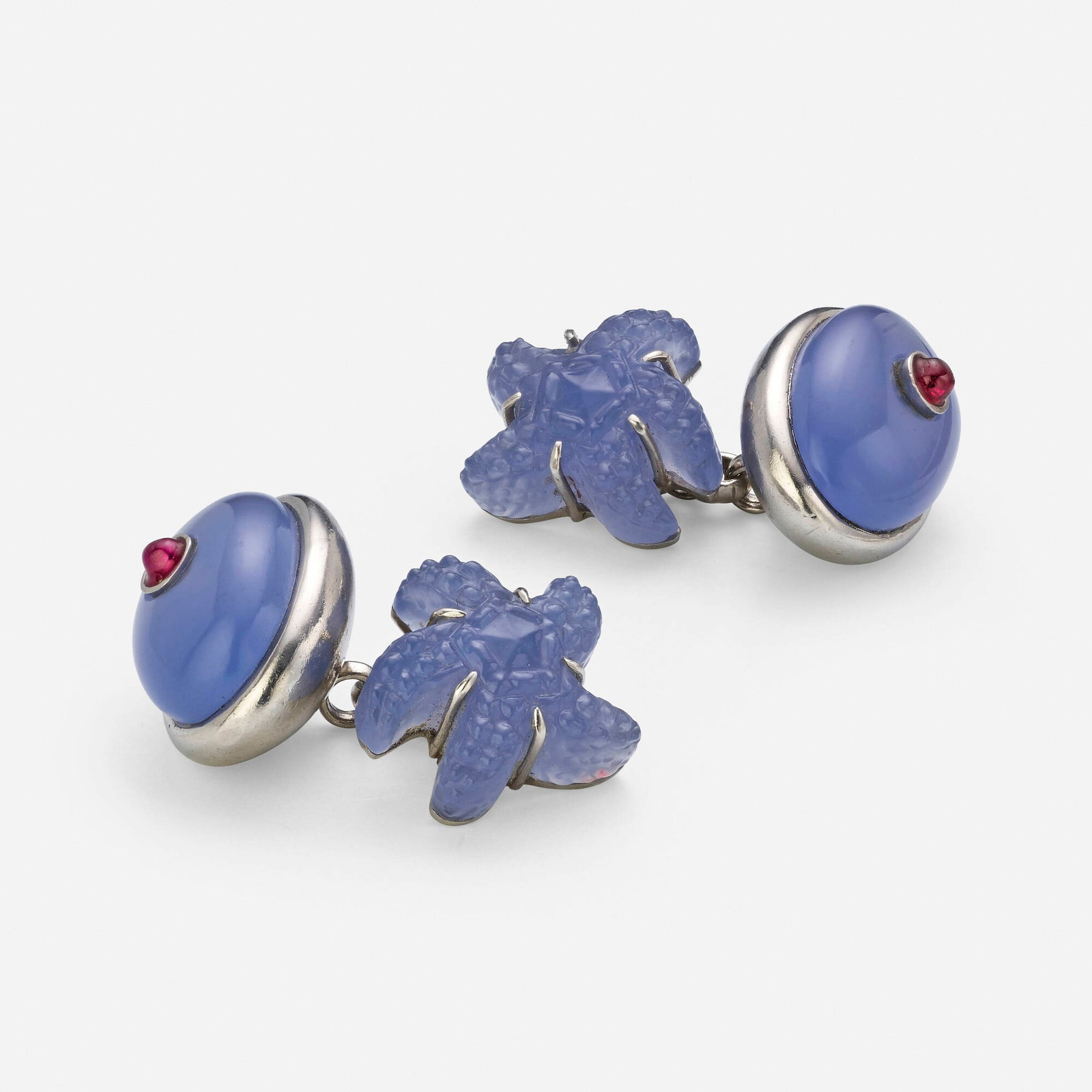 Blue chalcedony, ruby, and platinum cufflinks: Blue chalcedony, ruby, and platinum cufflinks Each set with a carved blue chalcedony starfish and a cabochon blue chalcedony inset with a cabochon ruby Platinum 1.25 x 0.75 in; Gross weight 23.3 dwts 
