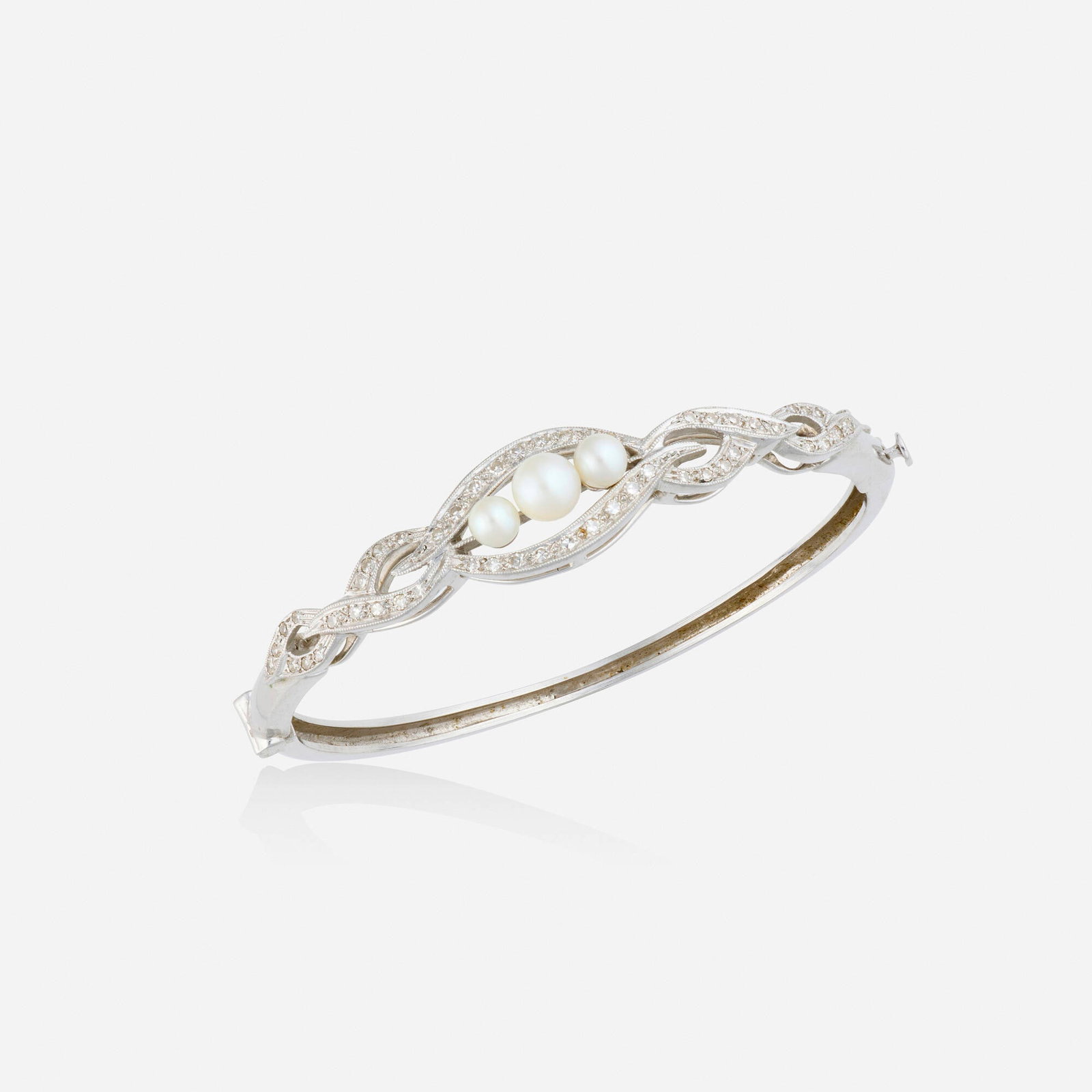 Cultured pearl, diamond, and white gold bracelet: Cultured pearl, diamond, and white gold bracelet The hinged bangle bracelet of scrolling design, set with cultured pearls and single-cut diamonds 14k white gold Inner circ. 6.50 in, width 0.50 in; Gro