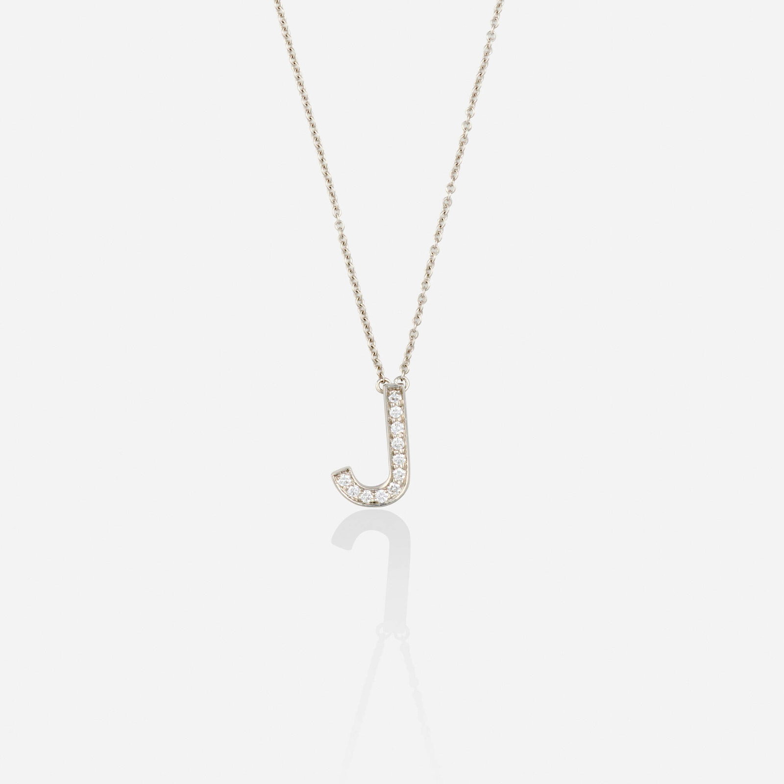Tiffany & Co., Diamond and platinum necklace: Tiffany & Co. Diamond and platinum necklace Designed with a 'J' initial pendant set with round brilliant-cut diamonds, suspended from the fine link chain; 2007 Platinum Signed Tiffany & Co.