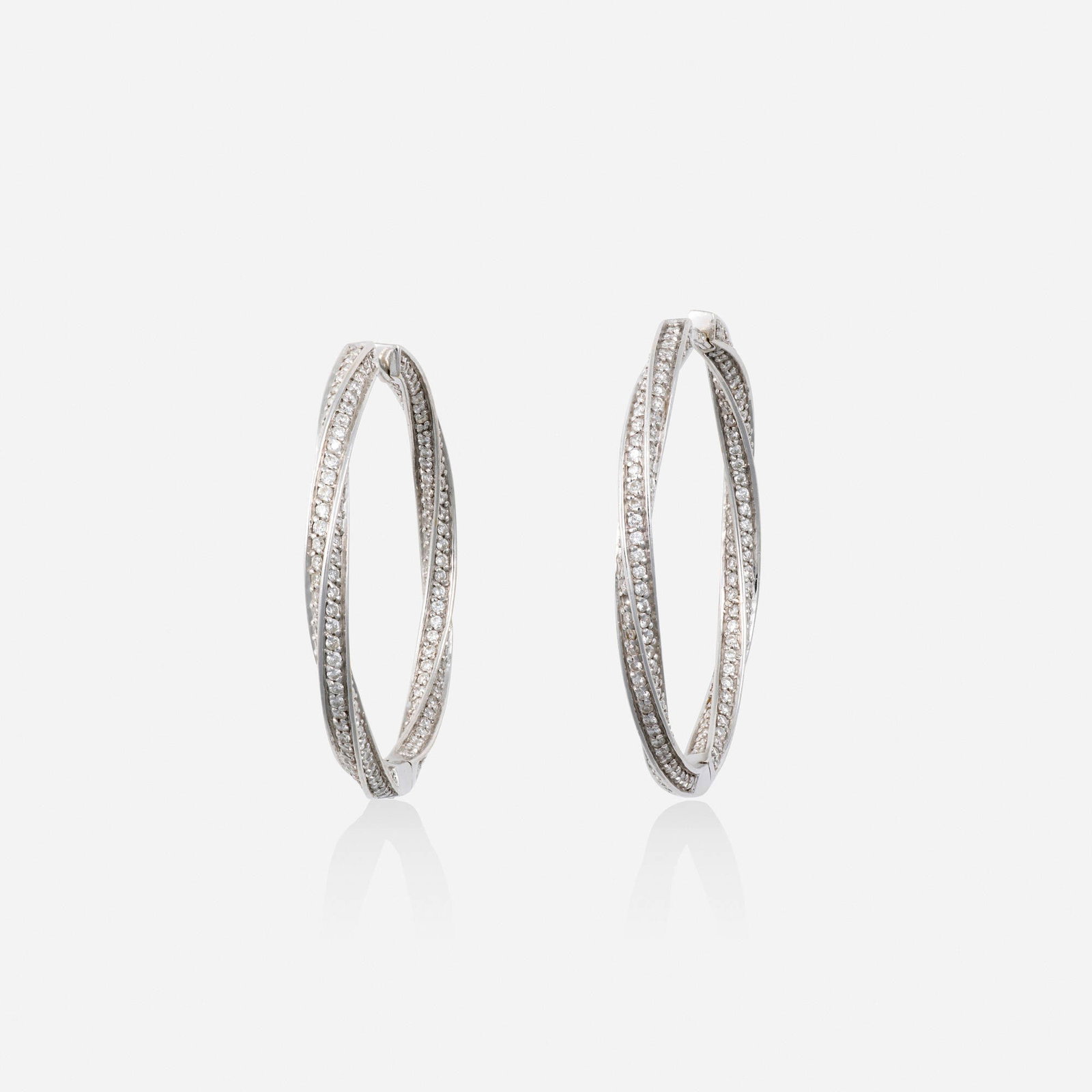 Diamond and white gold earrings: Diamond and white gold earrings Each a twisted hoop, set in and out with round brilliant-cut diamonds 14k white gold 1.375 x 0.125 in; Gross weight 4.8 dwts This work will ship from Lambertville, New 