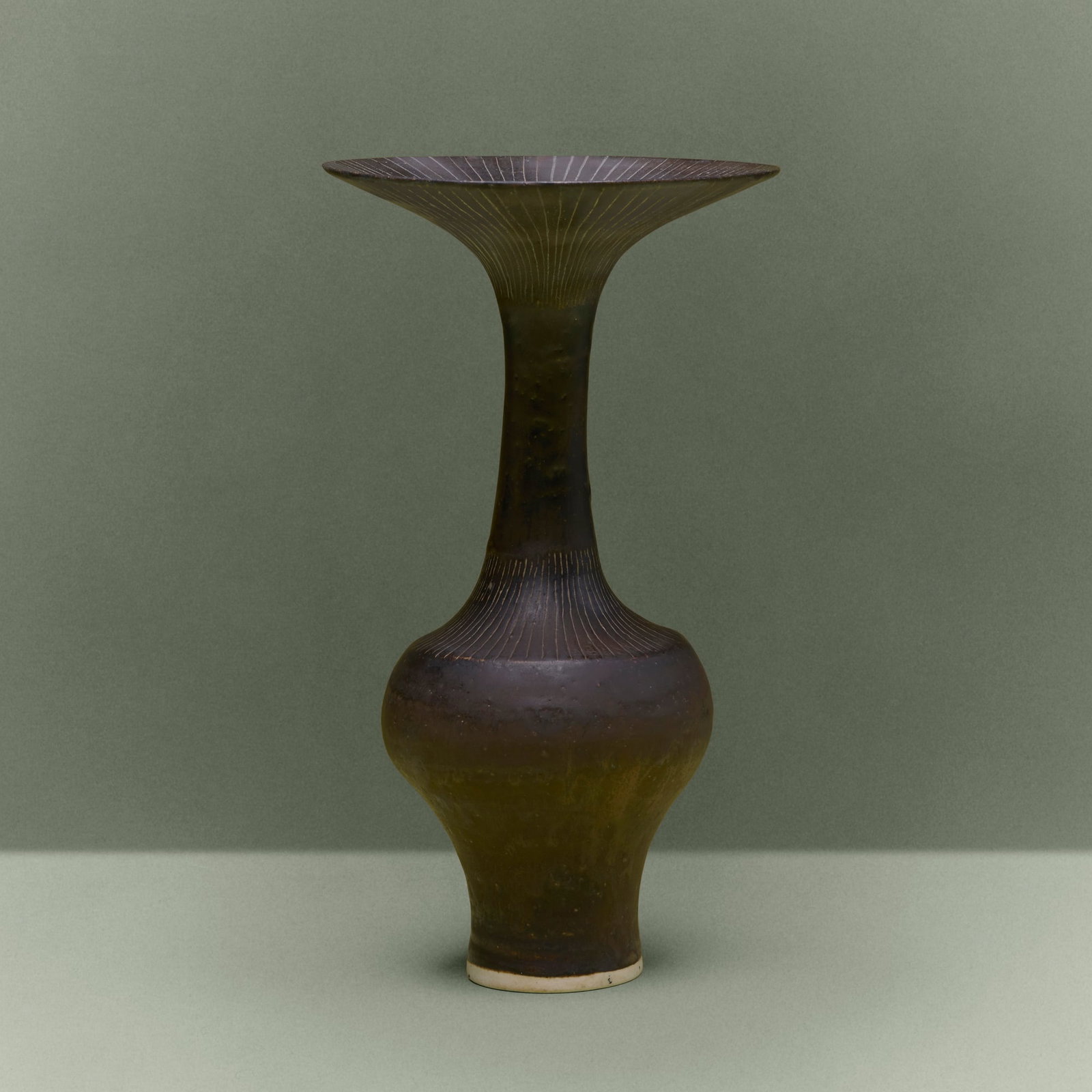 Lucie Rie, Bottle vase with flaring lip: Lucie Rie Bottle vase with flaring lip c. 1980 glazed porcelain with sgraffito decoration 9.5 h x 5.25 dia in (24 x 13 cm) Impressed artist's seal to underside. Provenance:<
