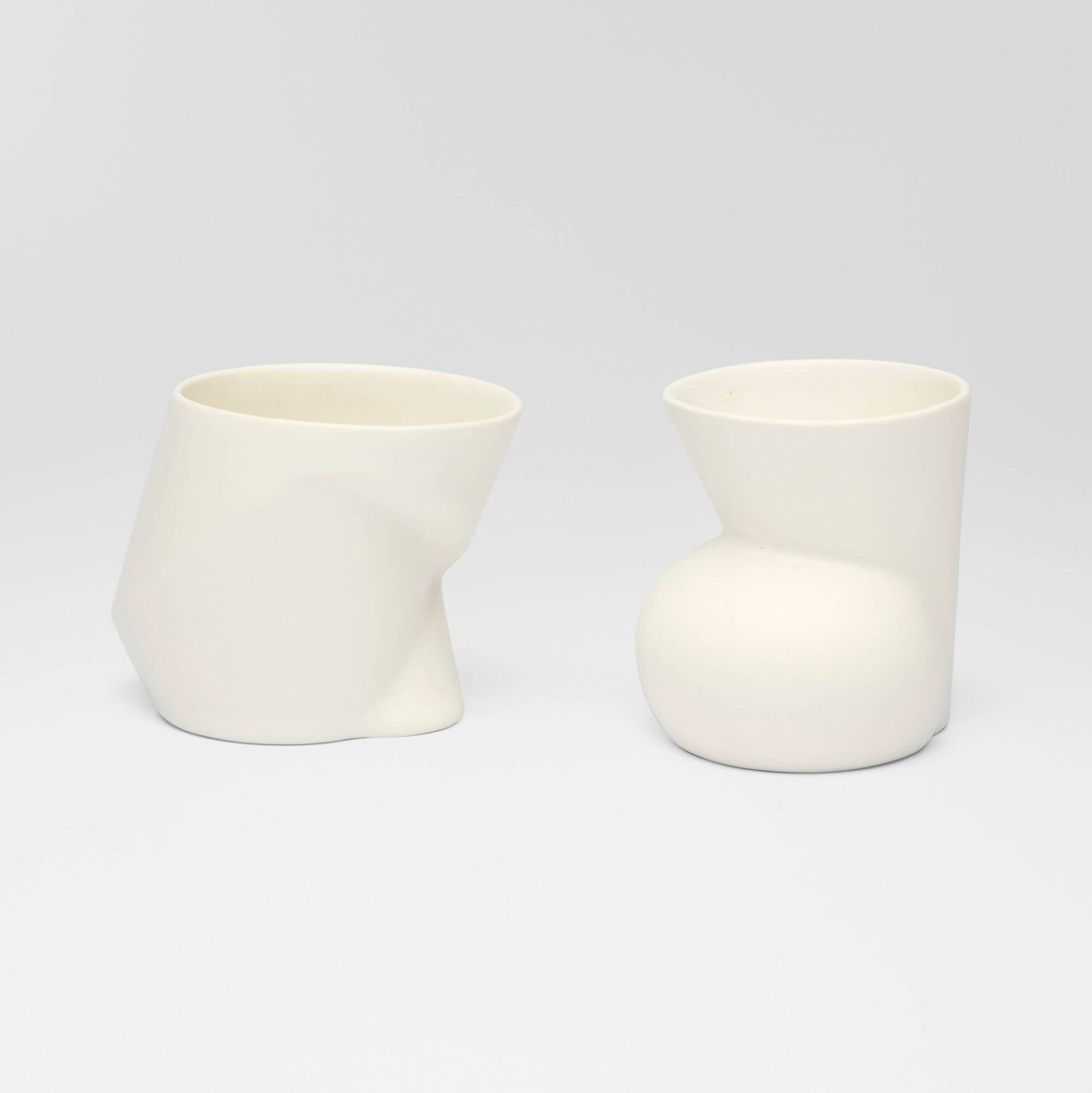 Anne Currier, Functionware cups, set of two: Anne Currier Functionware cups, set of two c. 2020 glazed porcelain 3.75 h x 3.5 w x 3.375 d in (10 x 9 x 9 cm) 3.5 h x 4.5 w x 3.25 d in (9 x 11 x 8 cm) Signed to each example 'IC AC'.