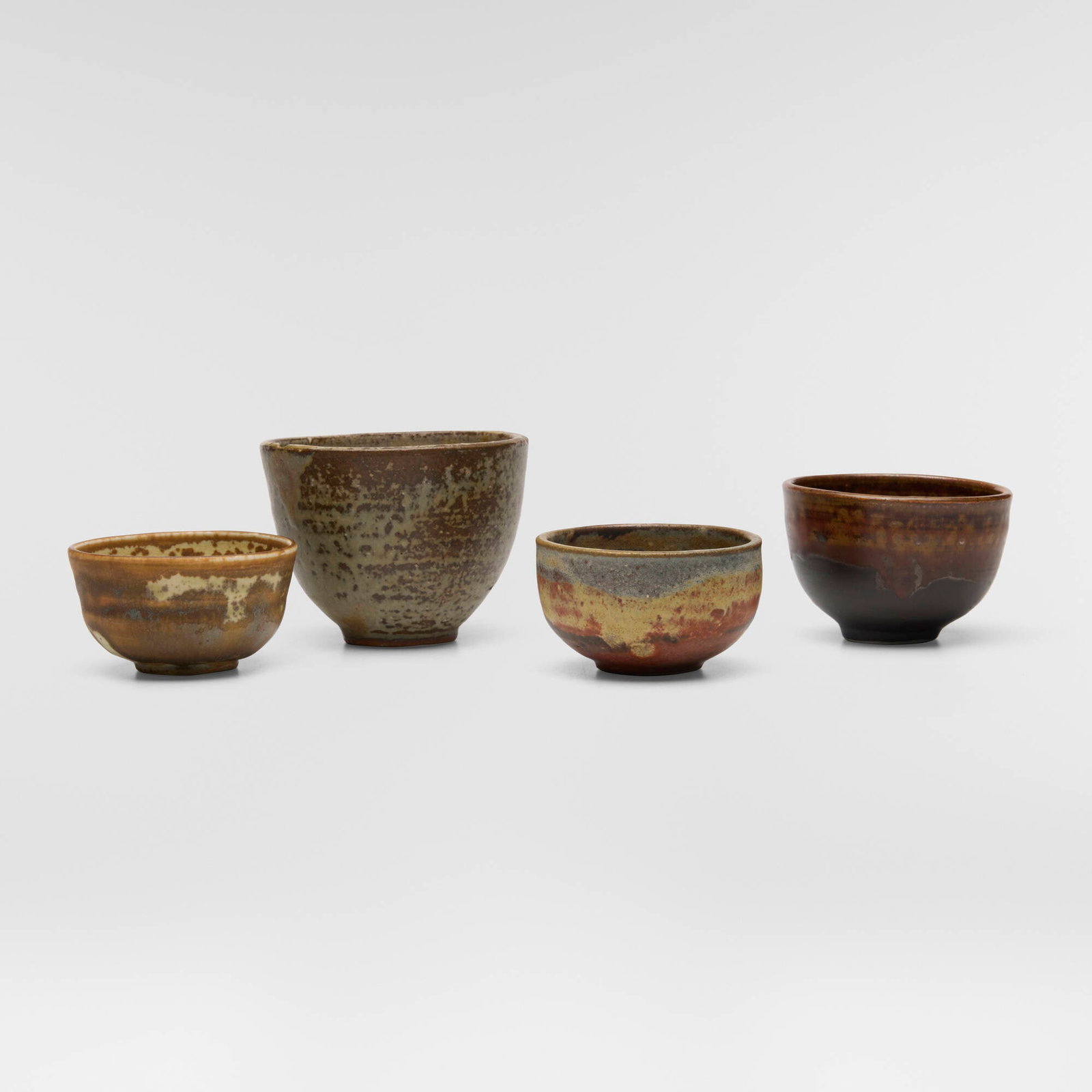 Toshiko Takaezu, Collection of four tea bowls: Toshiko Takaezu Collection of four tea bowls c. 1970-1975 glazed stoneware, glazed porcelain tallest: 2.75 h x 3.75 dia in (7 x 10 cm) shortest: 1.625 h x 3 dia in (4 x 8 cm) Incised signature to