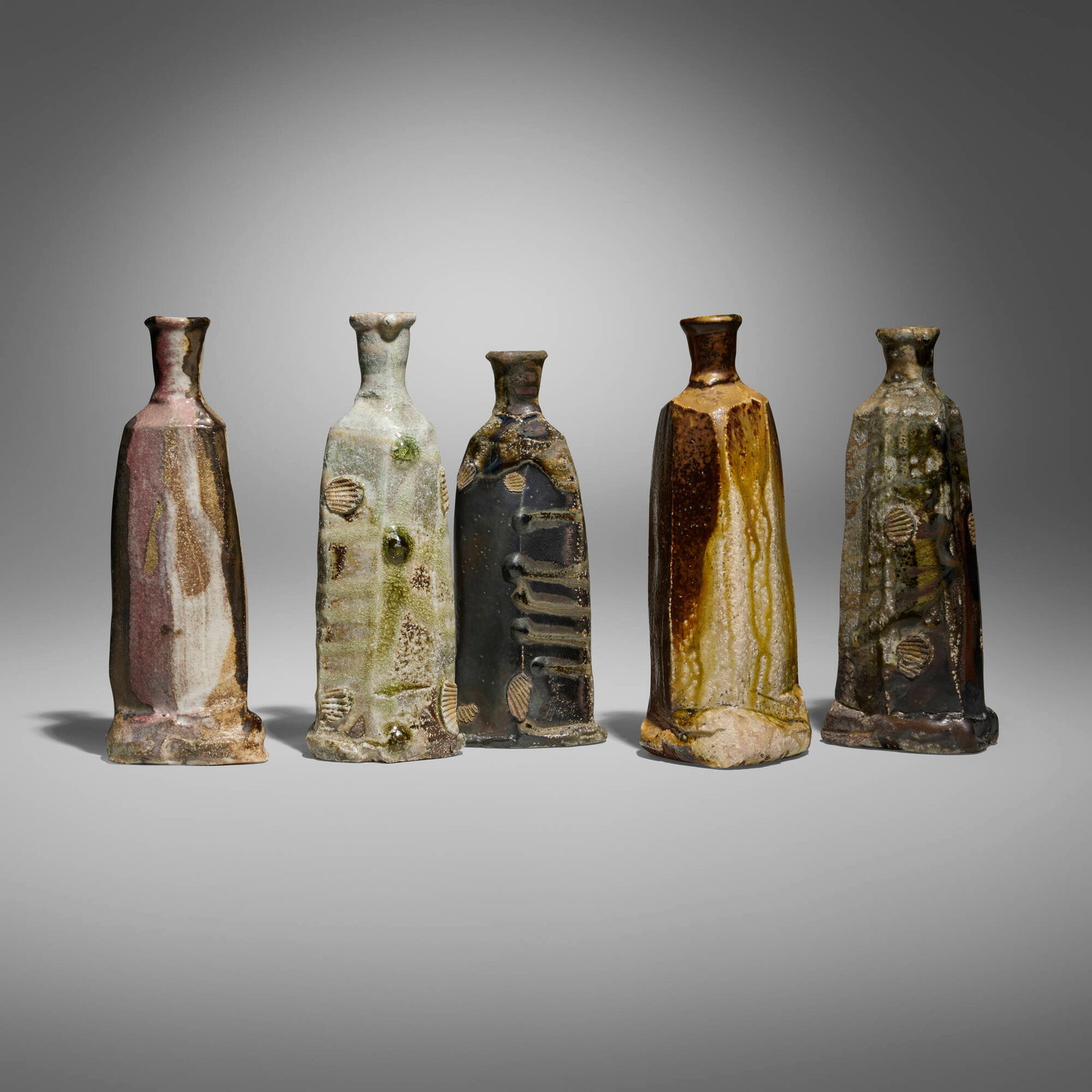 Jeff Shapiro, Collection of five bottles: Jeff Shapiro Collection of five bottles glazed and wood-fired stoneware tallest: 9.125 h x 3.5 w x 3.125 d in (23 x 9 x 8 cm) shortest: 8.25 h x 3.125 w x 3.25 d in (21 x 8 x 8 cm) Incised