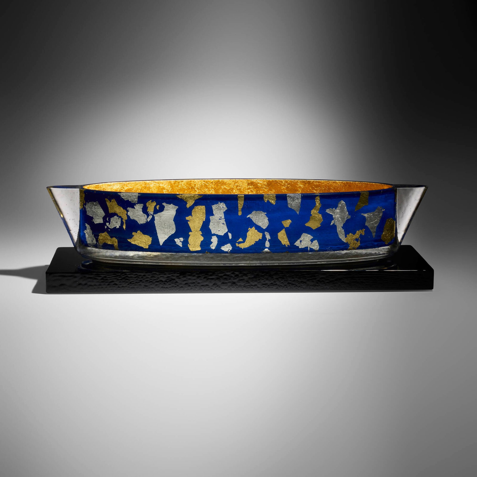 John Lewis, Blue Confetti Steamer Vessel: John Lewis Blue Confetti Steamer Vessel 2009 cast glass, tinted epoxy, gold and silver leaf 7 h x 29.25 w x 9 d in (18 x 74 x 23 cm) Etched signature, date, and number to lower side of vessel 'Le