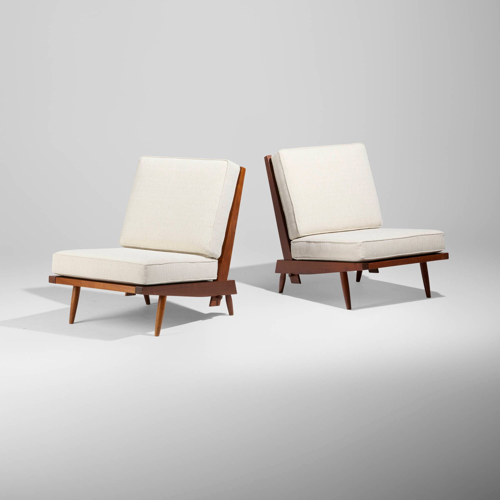 George Nakashima, Cushion chairs, pair: George Nakashima Cushion chairs, pair Nakashima Studio USA, 1963 American black walnut, upholstered cushions 32.5 h x 26 w x 34.75 d in (83 x 66 x 88 cm) Sold with a digital copy of the original