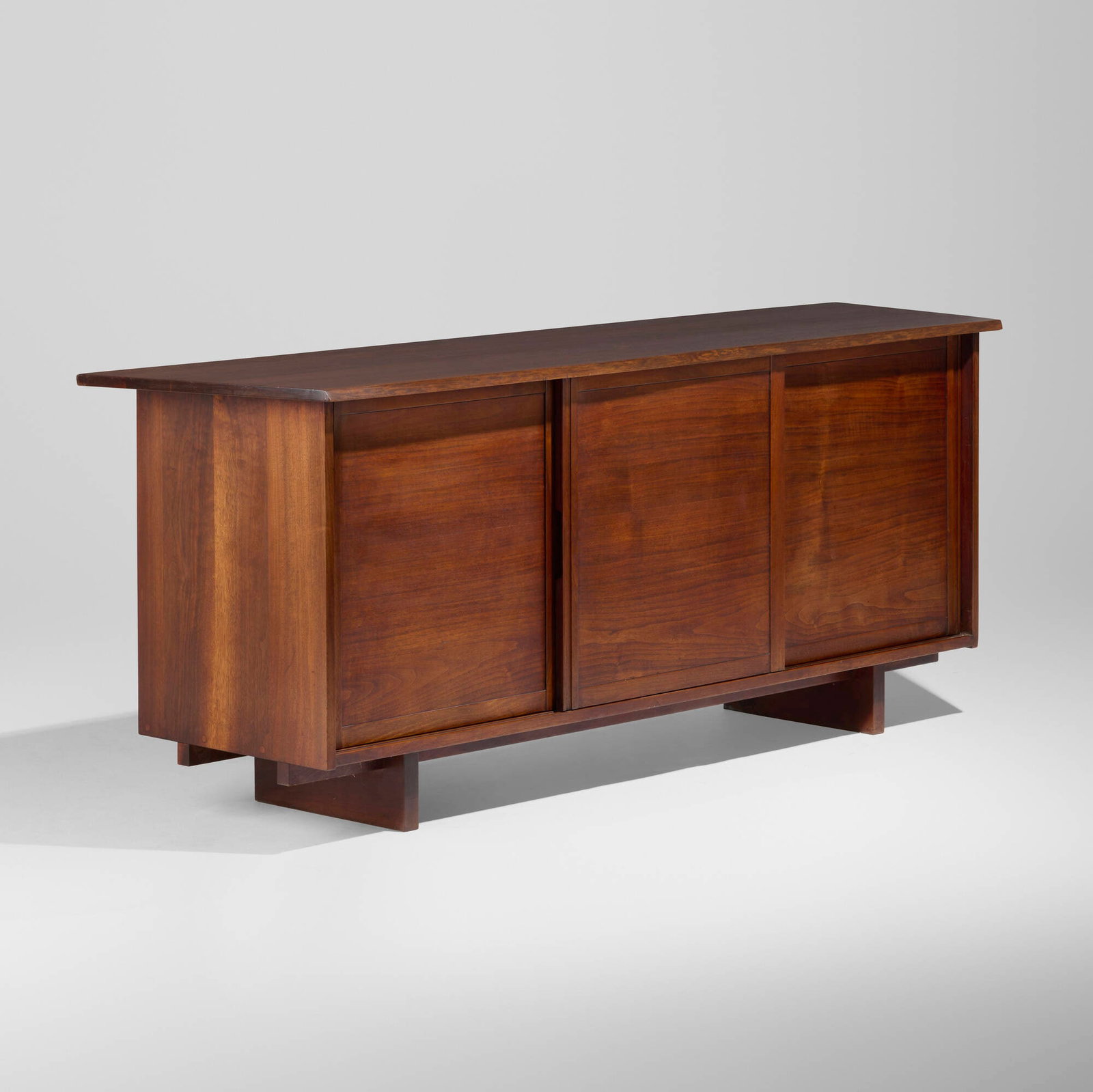 George Nakashima, Special-order Triple Sliding Door Radio cabinet: George Nakashima Special-order Triple Sliding Door Radio cabinet Nakashima Studio USA, 1956 American black walnut, oak, cast aluminum, enameled aluminum 31.5 h x 80 w x 21.5 d in (80 x 203 x 55 cm) C