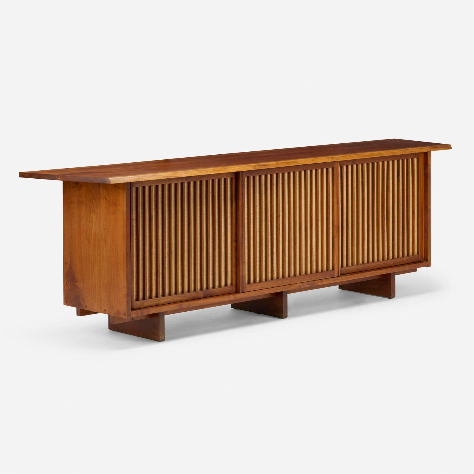 George Nakashima, Triple Sliding Door cabinet: George Nakashima Triple Sliding Door cabinet Nakashima Studio USA, 1972 American black walnut, pandanus cloth, oak 32 h x 104 w x 22 d in (81 x 264 x 56 cm) Cabinet features a double overhang, one fre