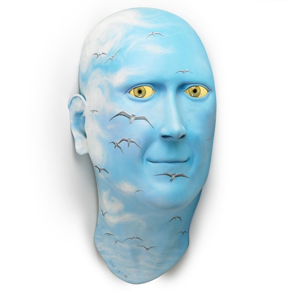JOHN WOODWARD Large blue head: JOHN WOODWARD (b. 1950) Massive wall-mounted ceramic head sculpture painted with birds in flight, 1994-5; Signed JGW 94-95; 33" x 17" x 13"