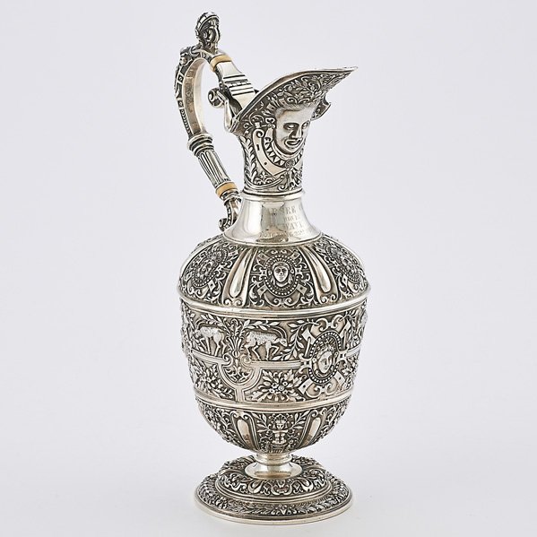 HONG KONG, BRITISH COLONIAL STERLING WINE EWER: Urn form trophy embossed with caryatids, masks, goats and fruits in the Renaissance Revival style, hinged, gilt spout, Steven Smith, London 1871; Neck inscribed "Parsee Cup, won by "Wave", Hong Kong, 