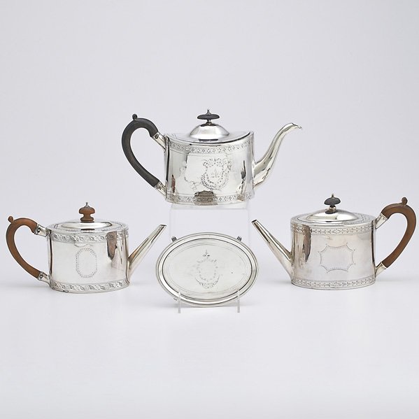 THREE GEORGE III SILVER TEAPOTS AND A STAND: Oval teapots with bright cut decoration, wood finials and handles: Possibly George Smith, 1788; R. & D. Hennell, 1796; Wm. Sutton, 1790; Oval teapot stand with stepped rim and fluted bracket feet, pos