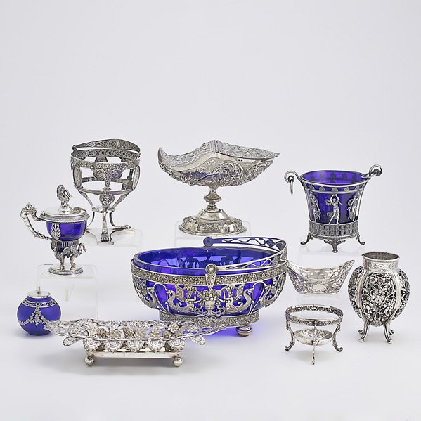 ORNAMENTAL CONTINENTAL SILVER: Ten pieces; Renaissance style basket with cobalt glass liner; Hinged repousse sugar on stand; Two basket frames (no liners); Cache pot with cobalt glass liner; Pierced gourd-form vessel; Reticulated b