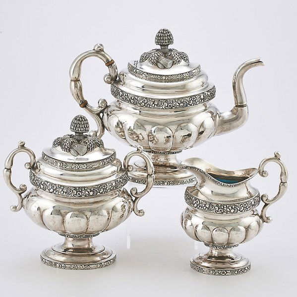 JOHN CRAWFORD AMERICAN COIN SILVER TEA SERVICE: Three melon-form vessels above oval pedestal foot, embossed floral bands, teapot with repousse wheat sheaf finial, gooseneck spout and ivory insulators, 12", cream pitcher and covered sugar bowl, New