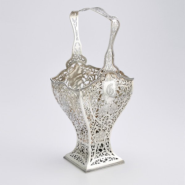 EDWARDIAN FIXED HANDLED STERLING BASKET: Squared baluster form and shaped handle scroll pierced with floral chasings; Meriden Britannia Co., ca. 1910; 18 1/2". 40.4 OT
