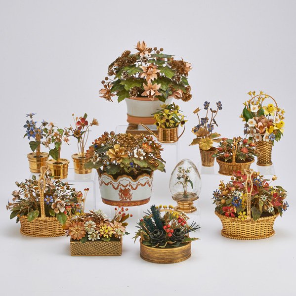 JANE HUTCHENSON, ETC. ENAMELED FLORAL ARRANGEMENTS: Two Fleurs des Siecles in silver gilt with pots by Gorham; One silver gilt watering can, retailed by Cartier; Three gilt metal baskets with winter or spring arrangements by Gloria Vanderbilt; Violet p