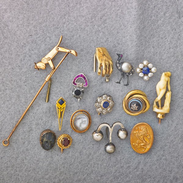 FOURTEEN GOLD OR SILVER STICK PINS: Gold mechanical climbing monkey stick pin, 4"; Ivory on gold bust of Venus; 14k yg. hand holds white gold and diamond jeweler's loupe; Art Deco black diamond, approx. 1 cts., cushion cut diamond and r