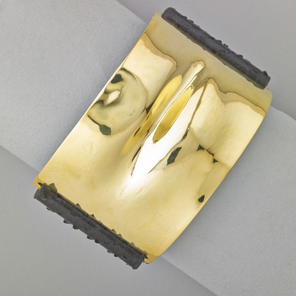 IPPOLITA 18K GOLD "PELLE KISS" CUFF: Sculptural contoured 18k gold and black python skin with gold button closure. Marked "Ippolita, Fatto a Mano, 18k". Adjusts for length 6 1/2" - 7 1/2" x 1 1/2". Collection of 2012. 40.1 dwt. GW