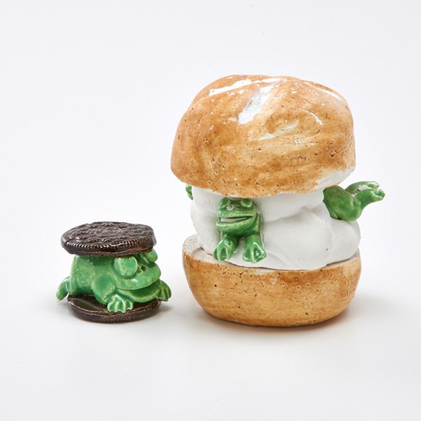 DAVID GILHOOLY: Two ceramic Frog Food sculptures: Frog on Roll and Frog Oreo, San Francisco, CA, 1978, 1991; Frog on Roll signed and dated; Taller: 4 1/4"