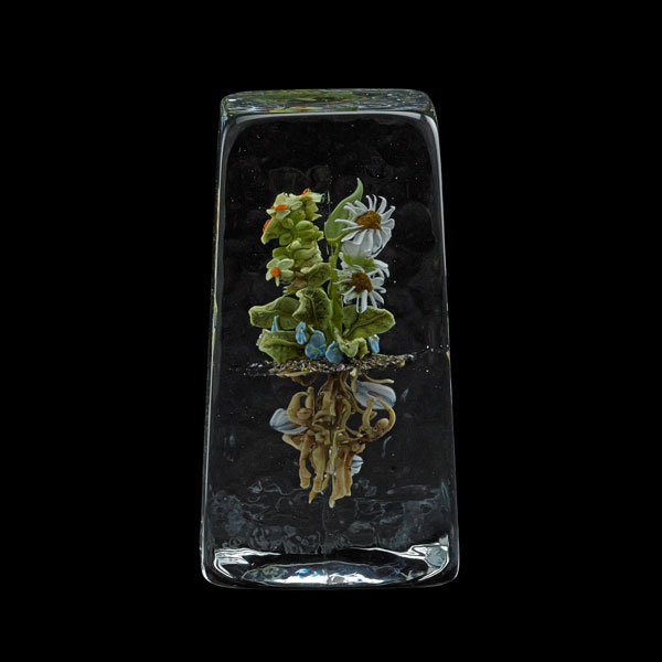 PAUL STANKARD Glass paperweight: PAUL STANKARD (b. 1943) Lamp-worked glass paperweight with flowers and figural roots, Millville, NJ, 1992; Etched Paul J. Stankard c41 92; 4 1/2" x 2 1/4' sq.