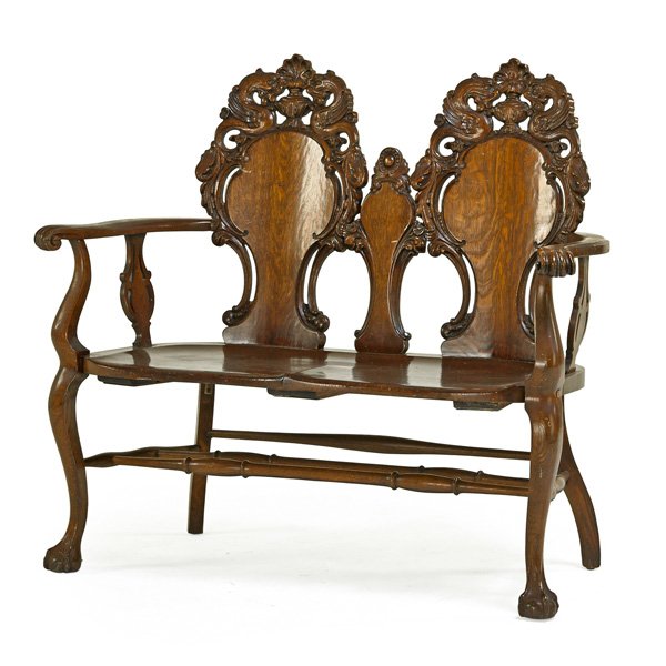 GOLDEN OAK CARVED BACK SETTEE: Quarter sawn oak with plank seat, on ball and claw feet, early 20th c.; 42" x 47" x 20"