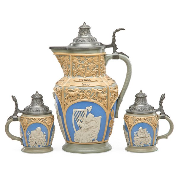 VILLEROY & BOCH / METTLACH STONEWARE DRINKING SET: Pitcher and pair of steins with figural cameo relief decoration, early 20th c.; All stamped Villeroy & Boch/Mettlach/1266; Pitcher: 12"