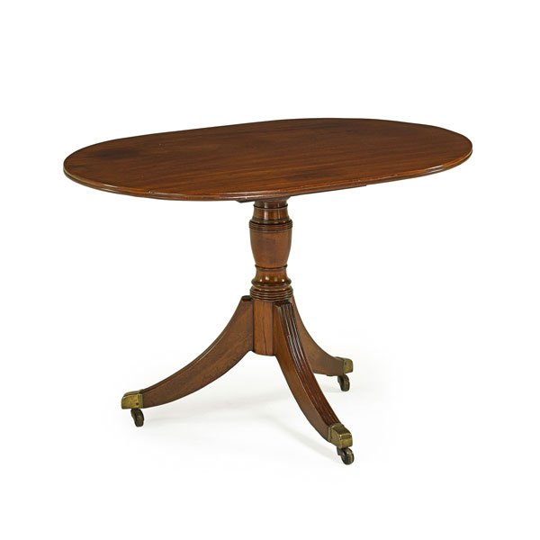 REGENCY OCCASIONAL TABLE: Mahogany with oval top and sabre legs on casters; 19th c.; 28 1/2" x 29 1/2" x 42"