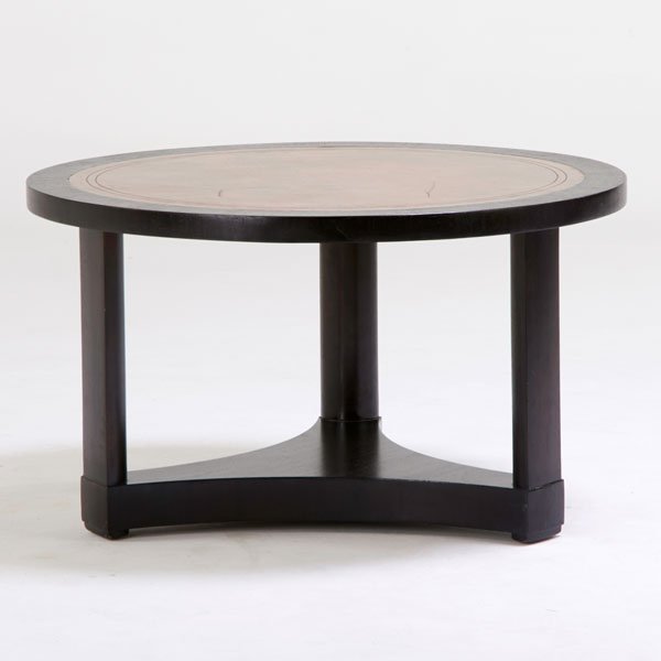 EDWARD WORMLEY; DUNBAR: Coffee table, Berne, IN, 1940s; Stained and lacquered mahogany, tooled leather; Paper manufacturer label; 20 1/2" x 35 1/2" dia.