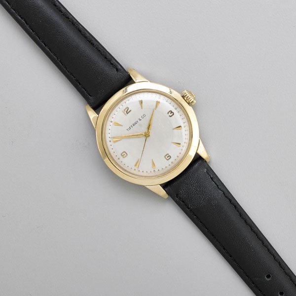 TIFFANY & CO. GOLD AUTOMATIC WRISTWATCH, MOVADO: Bumper movement 7522, c. 221A, #3058, case #A253058, Arabic quarters and dart hours, sweep seconds, 32 mm., on later strap